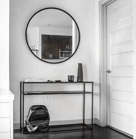 Duże czarne okrągłe lustro w przedpokoju