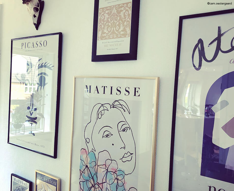 Ściana z obrazami z czarnymi i złotymi ramami