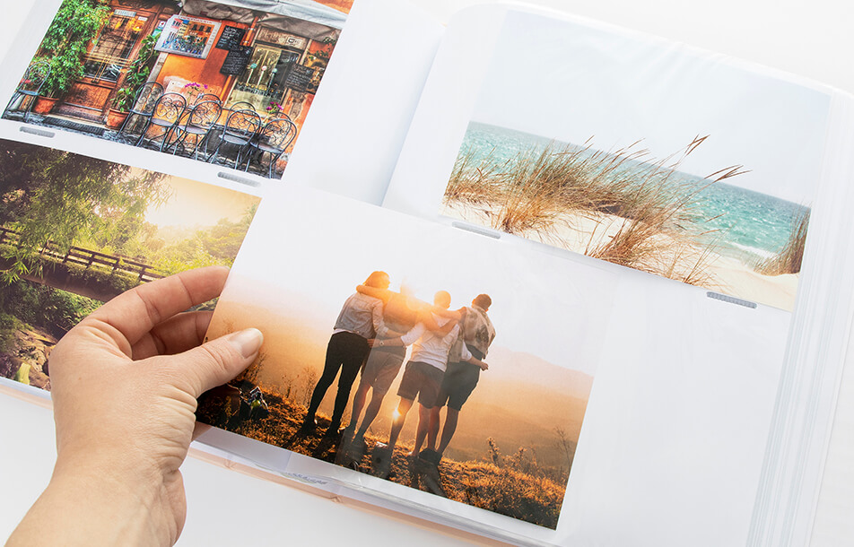 Otwarte fotoalbum z plastikowymi kieszonkami i zdjęciami
